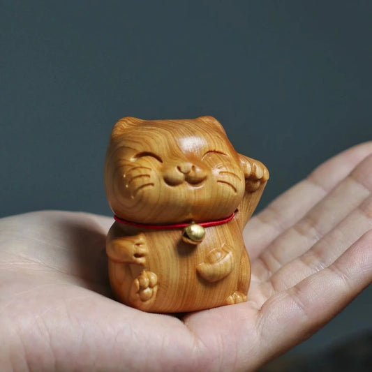 chat chanceux en bois dans la main
