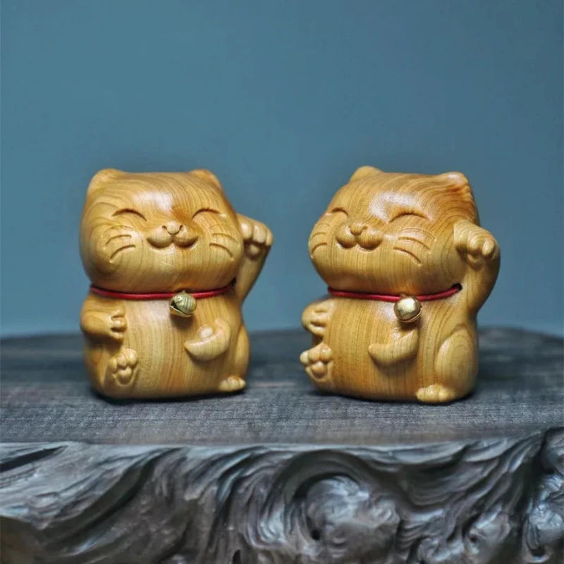 deux maneki neko en bois côte à côte